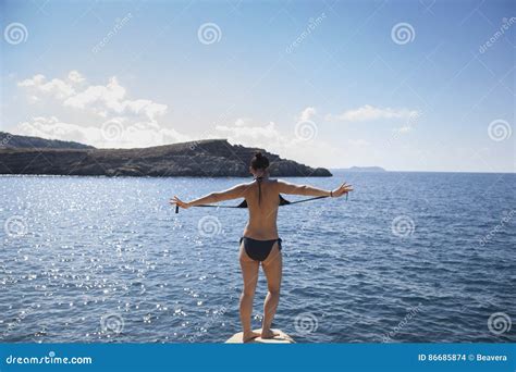 Adventurous Woman Removing Bathing Suit About To Jump Stock Photo