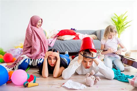Tired Parents And Romping Kids Stock Photo Download Image Now Chaos