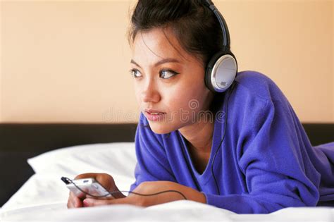 Young Woman In Headphones Listening To The Music In Bed Stock Image
