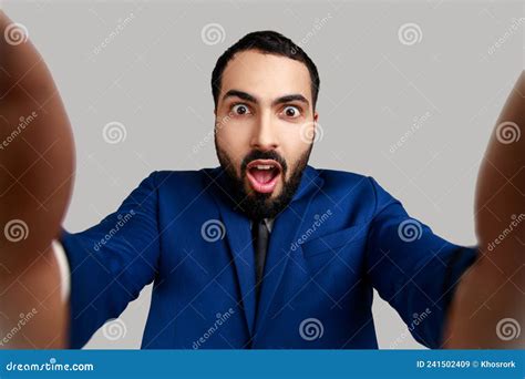 Young Adult Man Taking Selfie Looking At Camera With Shocked