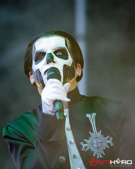 A Man With Black And White Face Paint Holding A Microphone