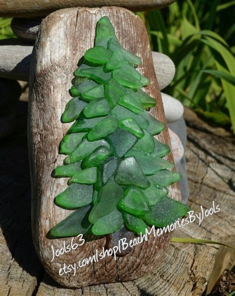 A Small Pine Tree Made Out Of Sea Glass Sitting On Top Of A Piece Of Wood