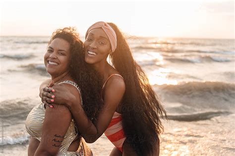 Two African American Female Friends Swimming And Laughing At The Beach