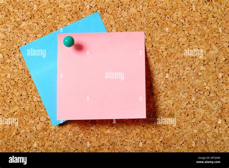 Two Posits Punctured With A Pin On A Green Corkboard Stock Photo