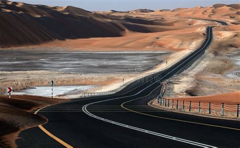 Winding Black Asphalt Road Through The Sand Dunes Of Liwa Oasis United