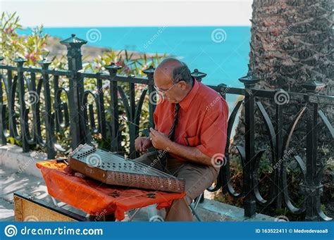 You can hum as well, which changes the sound. Tarragona, Catalonia, Spain August 9, 2013: An Elderly Musician Plays A Stringed Musical ...