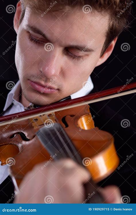 Sad Violinist Playing A Violin On A Dark Background Close Up Portrait