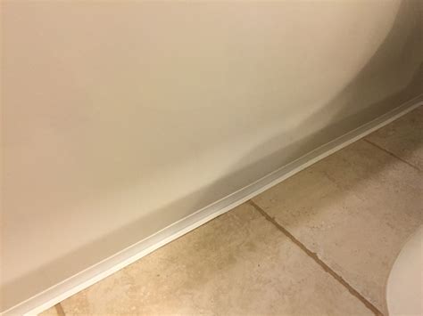 A precise and thorough caulking job is essential to keeping applying new caulking, or replacing bathtub calk, requires patience and care. Installing Caulk Strip Over Cracked Grout | Checking In ...
