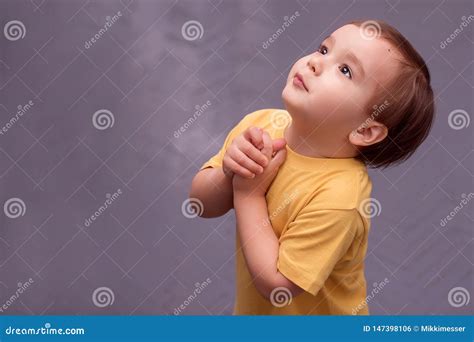 Side Portrait Of A Little Boy Begging Or Asking For Something Against