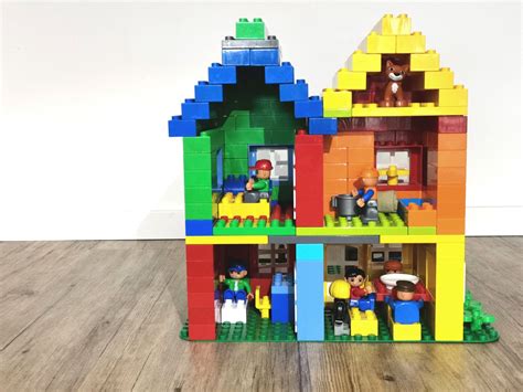 Familie spielen mit diesem einfach zu bauenden, dreistöckigen haus mit küche, badezimmer, waschbecken, schlafzimmer, kinderzimmer und dachterrasse sowie auto für stundenlangen kreativen. Lego Duplo Haus | Knutselen