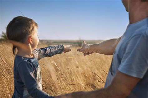 El Padre Y El Hijo En El Campo En La Puesta Del Sol Fingeres Del Punto