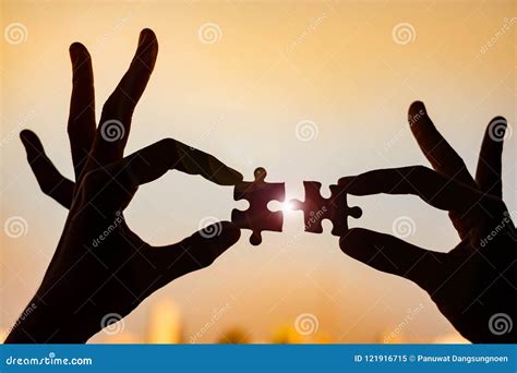 Hands Connecting Couple Puzzle Piece Against Sunrise Effec Stock Image