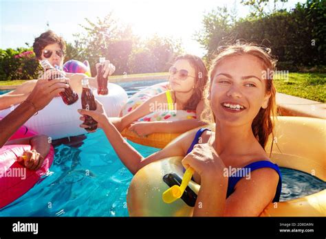 Teenage Girl Blow Noisemaker Party In The Swimming Pool With Friends