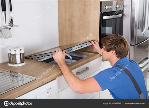 Las mejores cocinas con placas de inducción. Hombre instalar estufa de inducción — Foto de stock ...