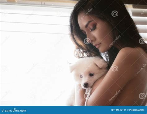 Mulher Do Nude Que Guarda Um Cachorrinho Bonito Imagem De Stock