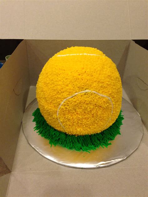 A Cake In A Box With Grass On The Bottom And Yellow Frosting Around It