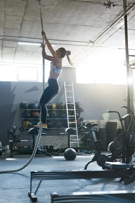 entrenamiento en el gimnasio atleta de sexo femenino climbing rope de crossfit foto de archivo
