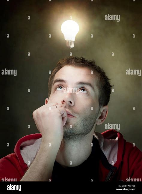 Young Man Having An Idea Light Bulb Above His Head Stock Photo Alamy