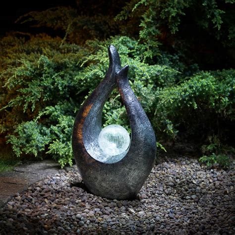 An enchanting fairy scene is brought together with gently flowing water to make a sweet focal point in your garden and outdoor spaces. Garden Gnome with Solar Powered Lamp Post | Garden Lighting