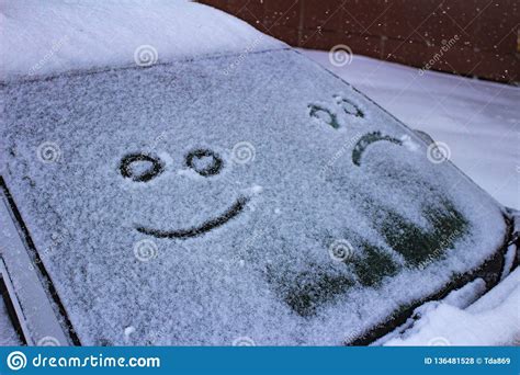 The Sad And The Happy Smile On The Snowy Windshield Of A Car Stock