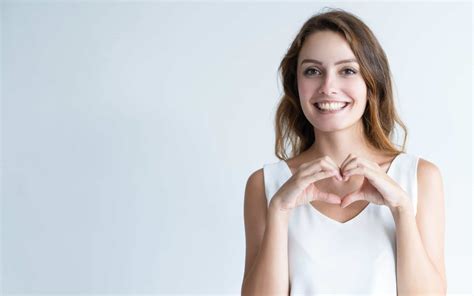 Smiling young woman making heart gesture with her hands • SeedTrust