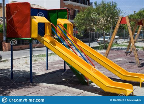 Screened Playground With Two Colorful Slides And Swing Neighbourhood