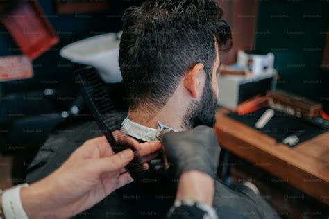 A Man Getting His Hair Cut By A Barber Photo Barber Image On Unsplash