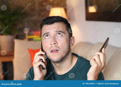 Young Overwhelmed Man Using Two Cellphones Stock Image Image Of