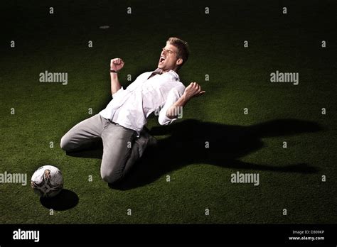 Footballer Shouting And Kneeling On Pitch Stock Photo Alamy