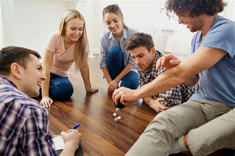 A deck of 52 cards is always fun for players of all ages. A Group Of Friends Play Board Games On The Floor Indoors Stock Photo - Download Image Now - iStock