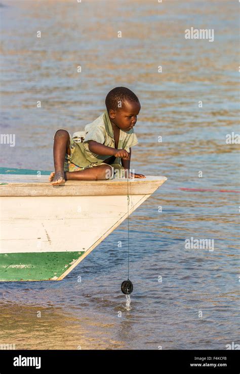 Local African Boy Playing At Fishing From A Fishing Boat Kaya Mawa