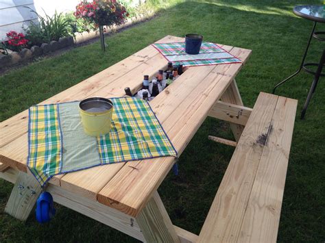 A Picnic Table Set Up In The Grass With Cups And Mugs Sitting On It
