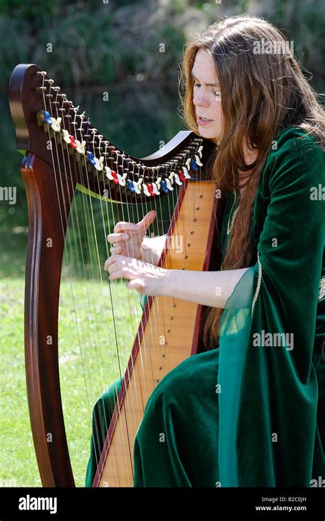 Female Musician In Medieval Costume Playing A Celtic Harp During The