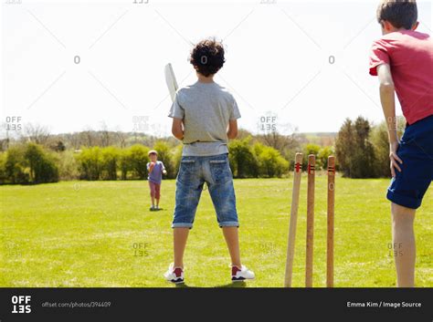 Boys Playing Cricket On Field Stock Photo Offset