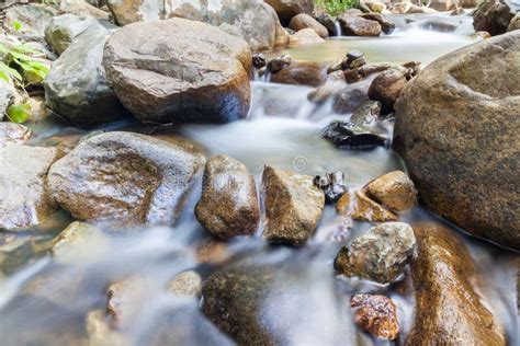 Clear Water Of Stream Flowing Through Natural Mountain Rocks Stock