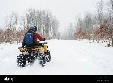 Man On A Quad Bike Next To A Woman Young Couple Doing Outdoor Winter