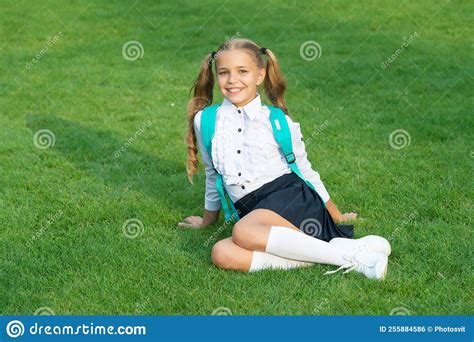 Happy Teen Girl In School Uniform Sitting On Green Grass Teenage Girl