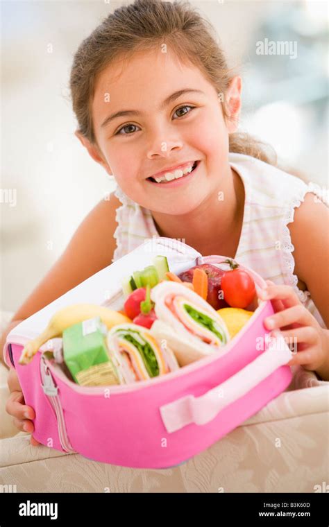 Young Girl Holding Packed Lunch In Living Room Smiling Stock Photo Alamy