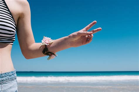 Girl At Beach Making Peace Sign With Her Fingers By Stocksy Contributor Jacqui Miller Stocksy