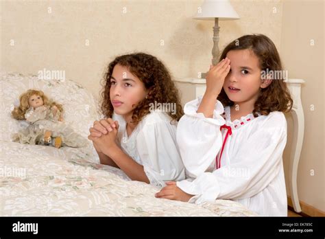Adorable Victorian Girls Kneeling In Their Vintage Bedroom And Praying