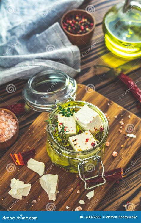 Feta Cheese Marinated In Olive Oil With Fresh Herbs In Glass Jar Stock