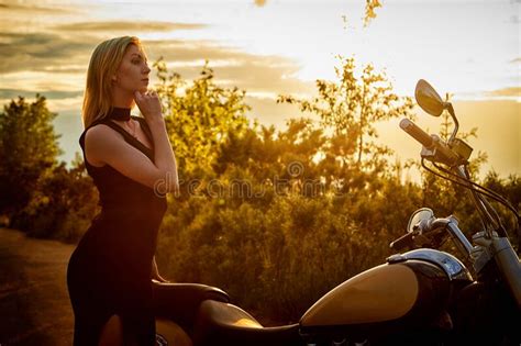 Attractive Female Brunette Motorcyclist With Motorcycle In A Summer Evening During Sunset