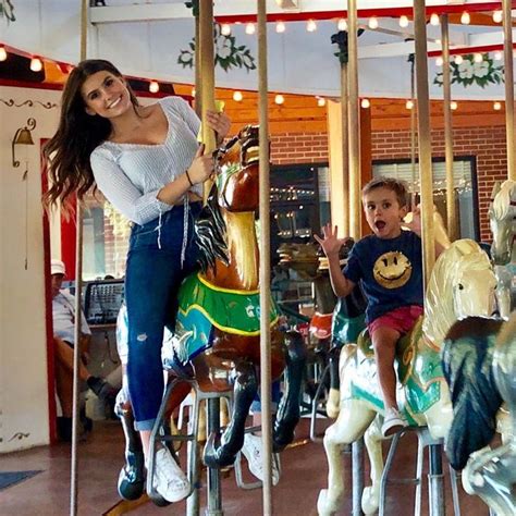 A Woman Riding On The Back Of A Merry Go Round With Two Babe Babes