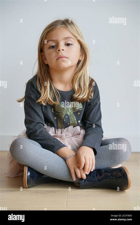 Cute Little Girl Sitting On Floor With Serious Look Stock Photo Alamy