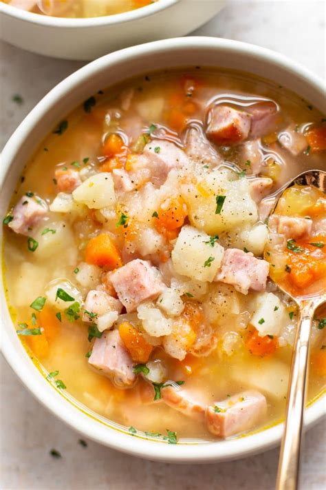 Two Bowls Of Ham And Potato Soup With A Spoon