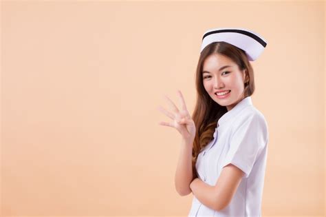 Enfermeira Asiática Apontando Quatro Dedos Para Cima Foto Premium