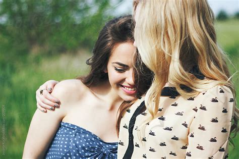 Two Female Friends Hugging And Laughing Outdoors By Jovana Rikalo