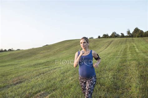 Young Pregnant Sporty Woman Running Outdoors — Runner Female Stock
