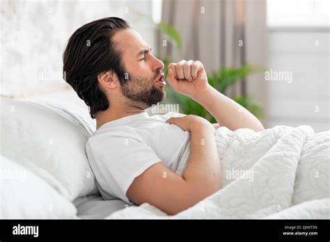 Sick Man Laying In Bed Coughing Touching His Chest Stock Photo Alamy
