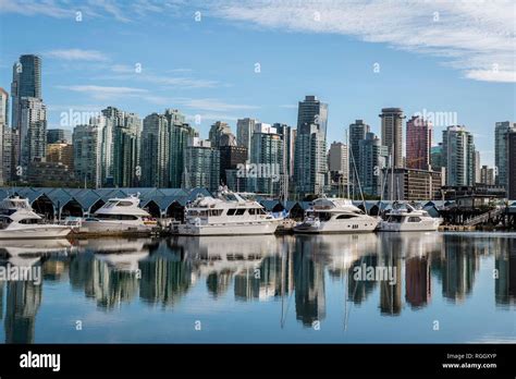 Skyscrapers And Sailboats In The Marina Skyline Of Vancouver Reflected